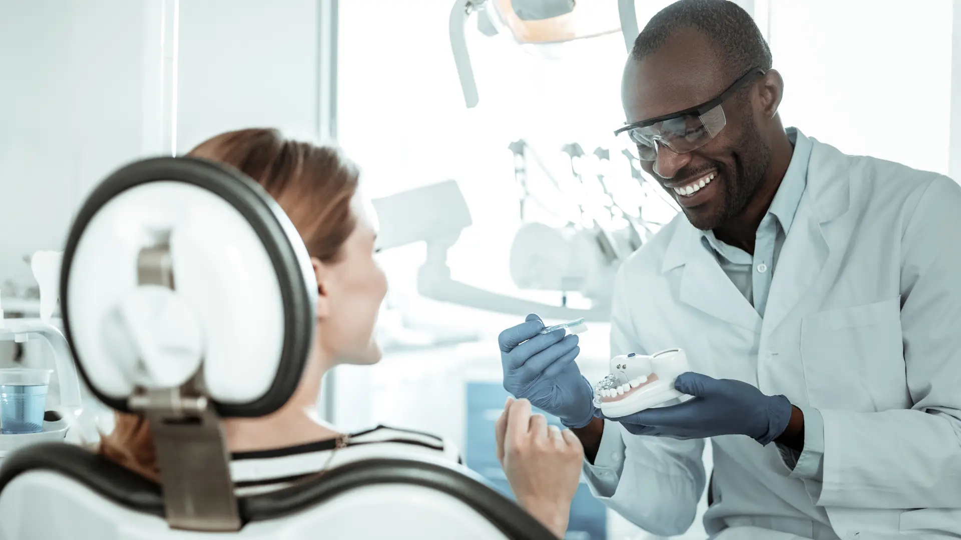 Associate dentist showing a patient how to brush.